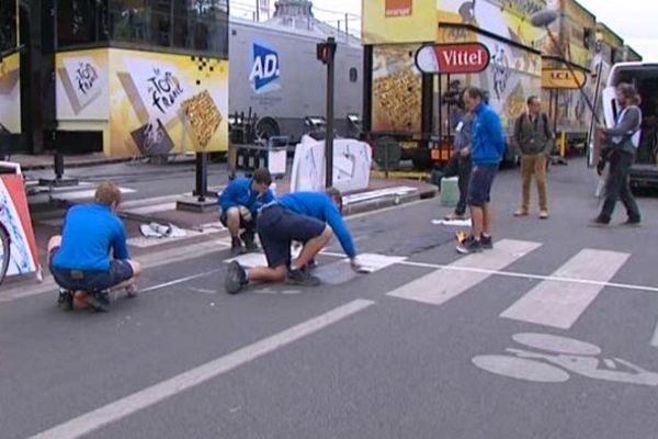 Les petites mains du Tour préparant la ligne d'arrivée