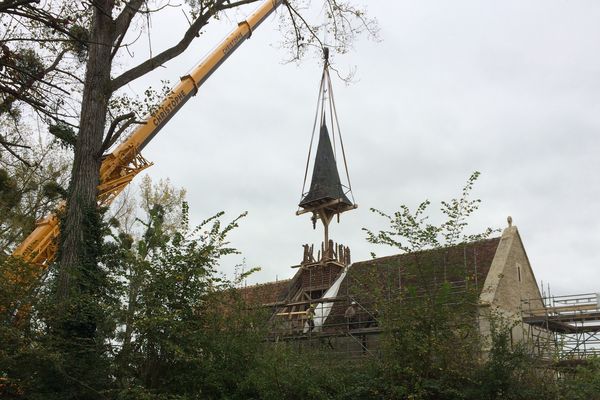 Une grue soulève le fût du clocher de l'église Sainte-Marie aux Anglais pour sa restauration en atelier