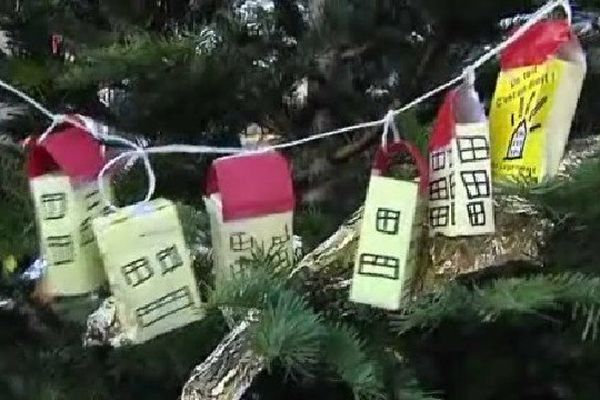 Des maisons de papier en guise de décoration sur le sapin des mal-logés