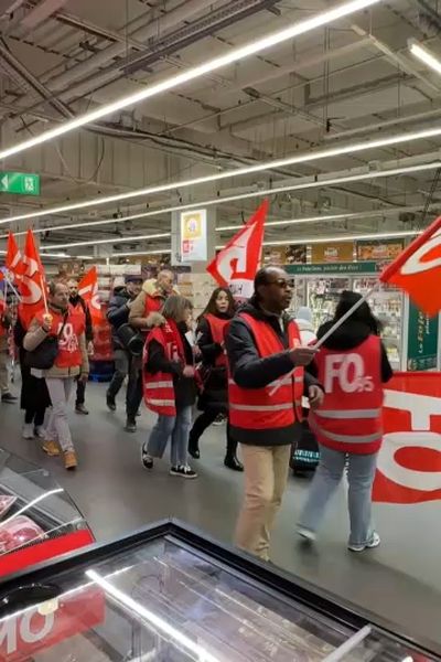 Des salariés d''Auchan défilent dans un hypermarché de leur enseigne à la Défense.