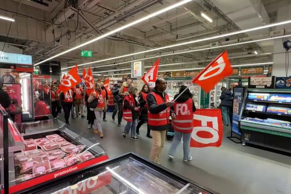 Des salariés d''Auchan défilent dans un hypermarché de leur enseigne à la Défense.