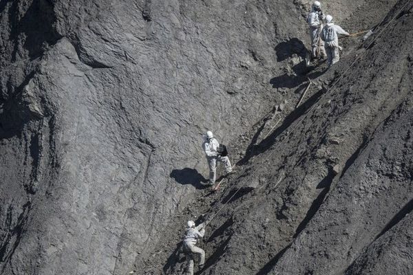 Des équipes sur les lieux du crash ramassent les derniers débris.