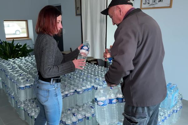 L'employée de mairie est en charge de la distribution d'eau en bouteille pour les habitants