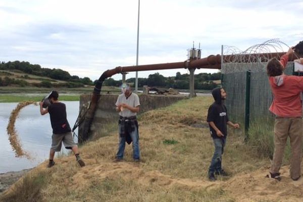 Des membres du collectif "grain de sable" rejettent symboliquement le sable extrait la semaine dernière par le bateau du groupe Roullier
