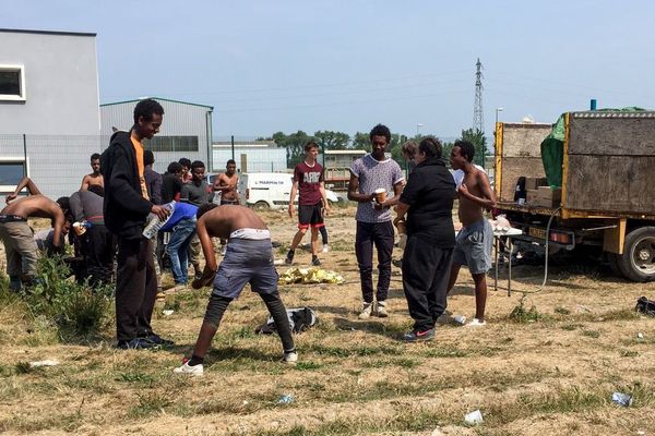 Des migrants prenant leur douche à Calais, le 21 juin 2017.