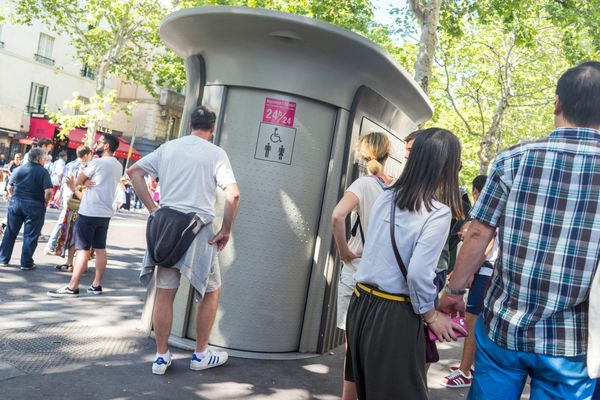 Des personnes attendent devant une sanisette à Paris