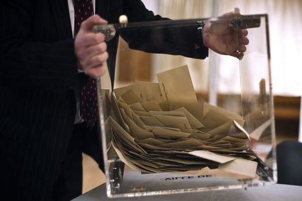 Un scrutateur vide l'urne contenant les bulletins de vote