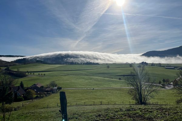 Une mer de nuages remonte en altitude et se déverse depuis la Suisse sur les montagnes du Jura.