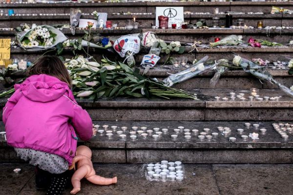 Une enfant allume une bougie devant un mémorial pour les victimes des attentats de Paris, à Lyon, le 15 novembre 2015 