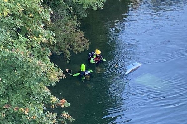 Deux plongeurs autour du véhicule immergé dans le Doubs le 9 octobre 2022.