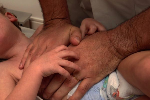 Un enfant pris en charge par un kiné pour une bronchiolite.