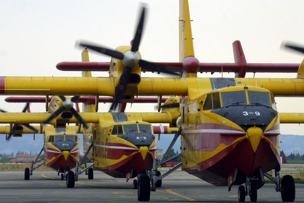 Trois Canadairs CL 415, de retour de mission sur des incendies, roulent le 14 août 2003 sur la piste de la base aéronautique de la Sécurite Civile de Marignane.