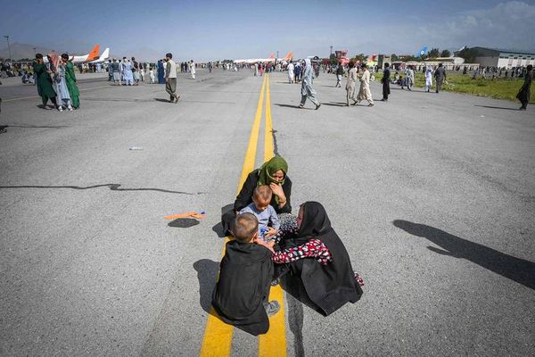 Des Afghans tentent de fuir le pays en attendant sur le tarmac de l’aéroport de Kaboul, lundi.
