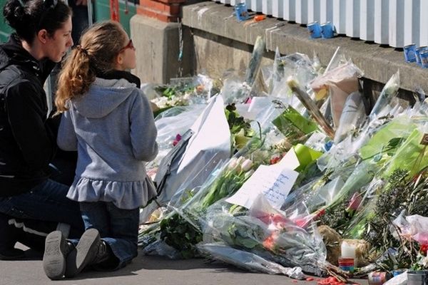 Des anonymes rendant hommage aux victimes de Mohammed Merah devant l'écorle Ohr-Torah en mars 2012