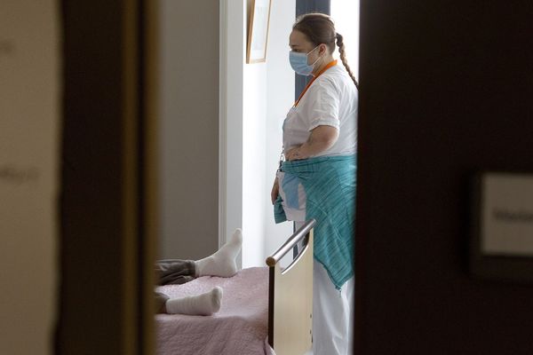 Une femme Agent de service hospitalier equipée de matériel de protection aide dans sa chambre une résidente d un EHPAD proche de Montpellier qui a été placée en isolement lié a l'épidemie de coronavirus. 