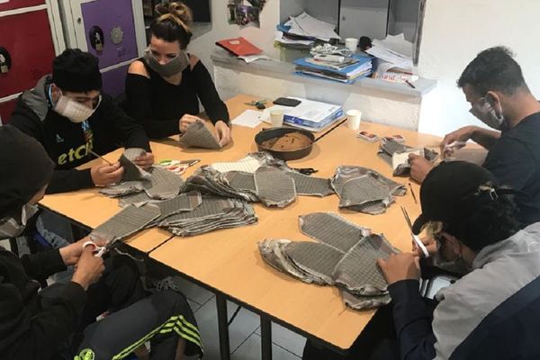 Des jeunes du Centre Éducatif Albatros de Cornebarrieu (31) découpent des masques en tissus.