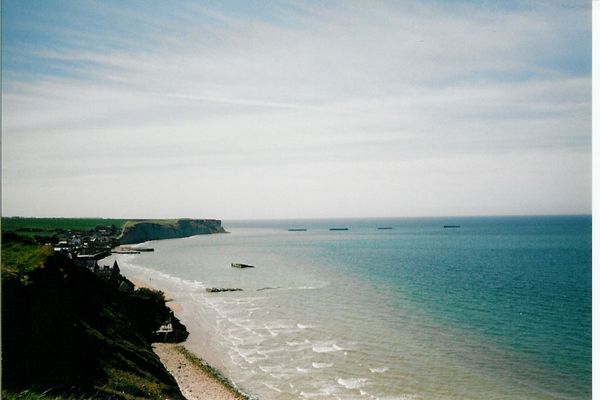 Dans le Calvados, ombre et lumière sur Arromanches, sous un ciel voilé.