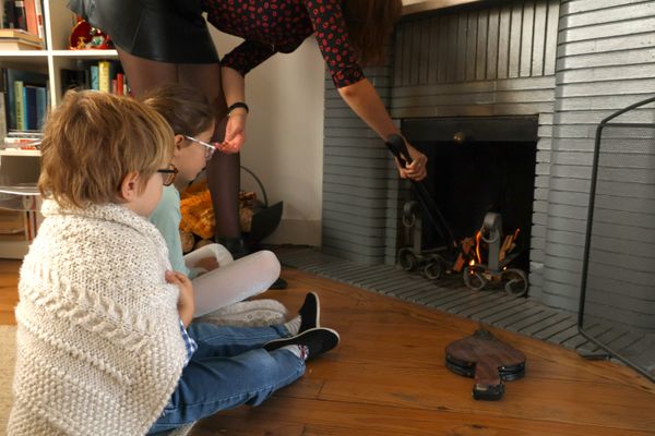 Une famille qui se chauffe à la cheminée.