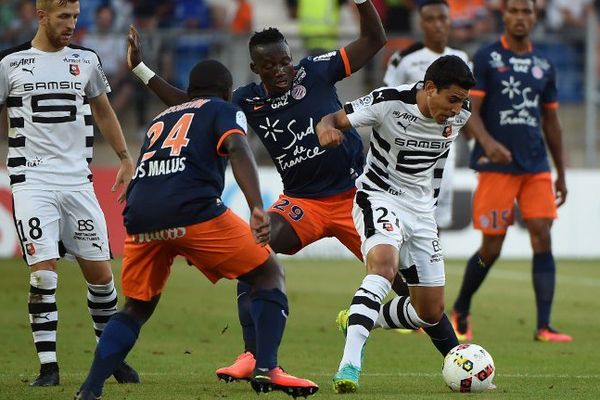 Le milieu de terrain rennais Benjamin Andre (au centre en blanc) aux prises avec le défenseur montpelliérain Jerome Roussillon lors du match de Ligue 1 entre Montpellier et Rennes au Stade de la Mosson - 27/08/2016