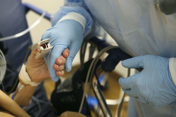 A l'hôpital de Bastia, une patiente en soin Covid-19 tient la main d'une membre du personnel hospitalier, le 15 décembre 2021.