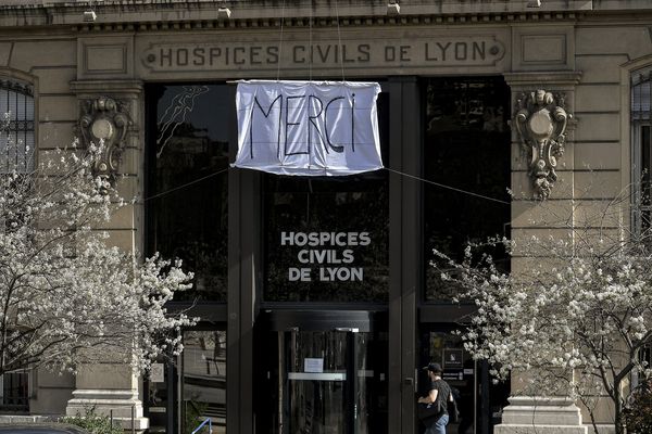 Un drap blanc sur lequel est inscrit le mot "merci" est attaché sur la façade du siège social des Hospices Civils de Lyon (HCL) au troisième jour de confinement en raison de la pandémie de Coronavirus Covid-19.