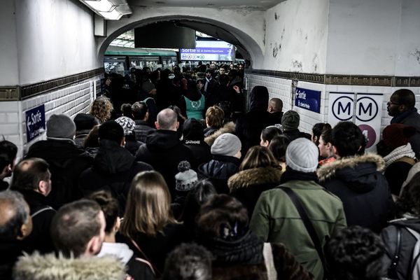 Des voyageurs font la queue en tentant d’emprunter la ligne 1 du métro parisien, lors de la grève du jeudi 12 décembre.