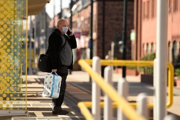 Un passant dans une rue d'Oldham dans le nord-est de l'Angleterre.