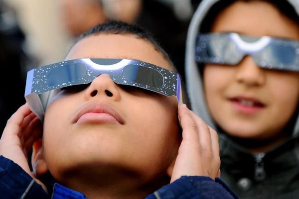 Deux enfants regardent une éclipse partielle de Soleil, le 4 janvier 2011, à Tunis (Tunisie). 