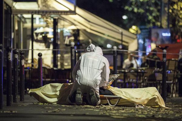 Des policiers français interviennent auprès d'une victime de la série d'attentats perpétrés à Paris, le 13 novembre 2015