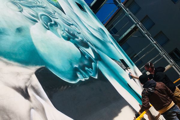 L'artiste NaCle a pour mission de créer une fresque de 16 mètres de haut sur la façade de cet immeuble bisontin en rénovation.