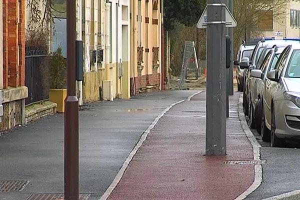 La piste cyclable est jonchée de poteau de lampadaires (piste rouge au sol).