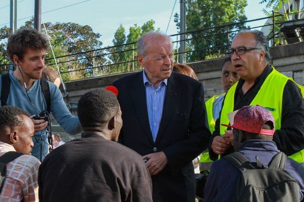 Jacques Toubon discutant avec des réfugiés lors de sa visite. 