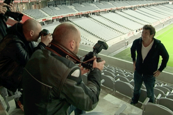 Patrick Bruel pose pour les photographes dans les tribunes du Stade Pierre Mauroy.