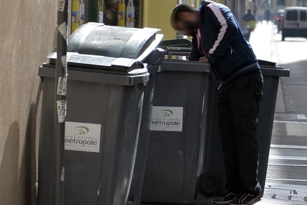 Un homme fouille une poubelle à St Etienne 