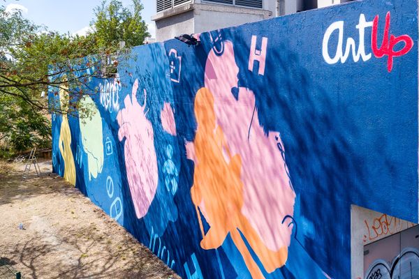 La fresque d'hommage aux soignants a été réalisée sur un mur d'un local technique du groupement est des Hospices Civils de Lyon. Bien visible depuis le périphérique, elle donne du baume au coeur des professionnels de santé qui luttent contre l'épidémie de Covid-19.