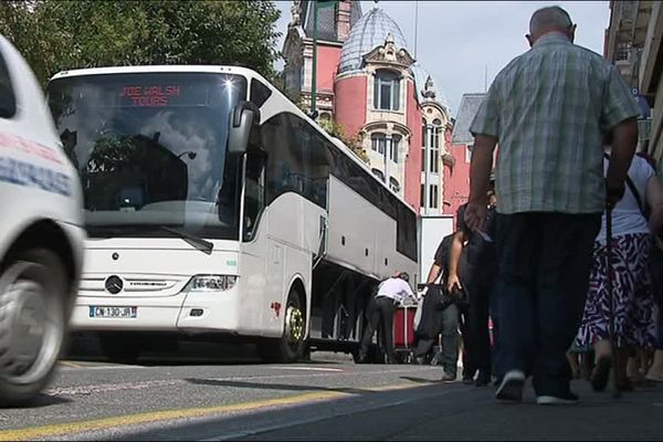 Cars, voitures et pèlerins cohabitent dans les rues de Lourdes