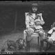 Jacques assis, avec deux poupées et un lion en peluche, dans le jardin de Verneuil photographié par son père Emile Zola,1894-1902