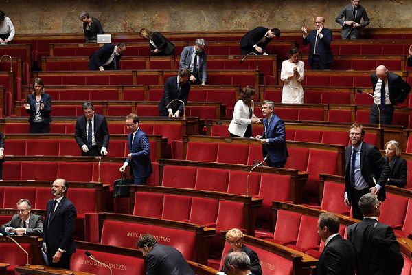 Le Premier ministre Edouard Philippe, se lève, mardi 28 avril, au moment des débats sur la présentation de son plan de déconfinement à l'Assemblée nationale. Seuls 75 députés ont pu siégé physiquement. Les autres ont participé et voté à distance.

