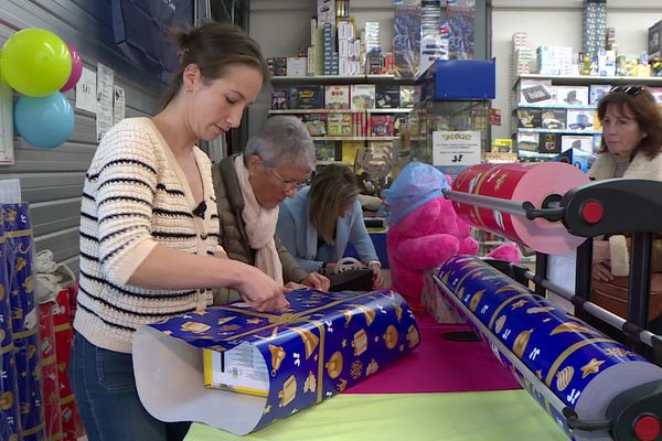 Les clients font emballer leurs cadeaux de Noël et font un don au profit d'une association