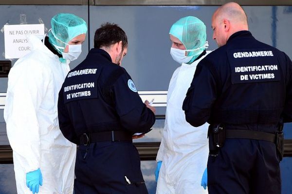 Des policiers devant un laboratoire mobiles où sont réalisés des tests ADN pour indentifier les victimes du crash de la Germanwings, le 27 mars 2015 à Seyne-les-Alpes. 