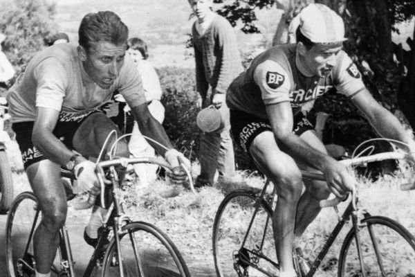 Le Français Jacques Anquetil (G), maillot jaune de leader, est au coude à coude avec son compatriote Raymond Poulidor dans l'ascension du Puy de Dôme, le 12 juillet 1964 lors de la 20ème étape du Tour de France, menant les coureurs de Brive à Clermont-Ferrand.