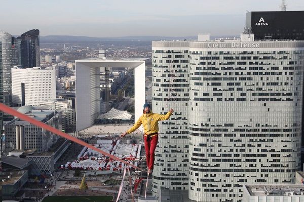 Le slackliner Nathan Paulin effectue une traversée entre deux tours du quartier de La Défense à Coubevoie le 22 novembre 2011 dans le cadre du Téléthon 2019