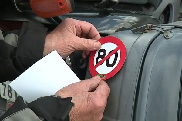 Un motard ajoute un autocollant sur son véhicule avant de prendre le départ de la manifestation ce samedi 14 avril. 