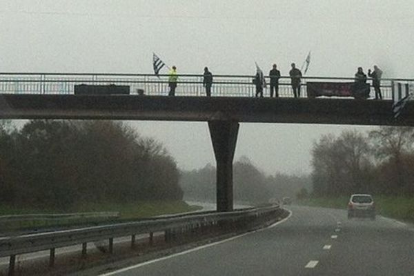 "Taxes trop c'est trop !", une banderole des bonnets rouges sur un pont enjambant la RN 24.