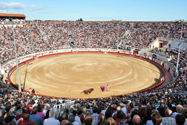 Les arènes de Béziers dans l'Hérault noires de monde pour assister aux corridas et novilladas lors de la feria - Illustration.