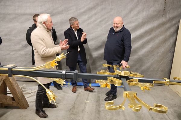 Présentation de la croix sommitale à Philippe Villeneuve (à gauche), architecte en chef des monuments historiques et Philippe Jost (au milieu), président de l’établissement public Rebâtir Notre-Dame de Paris, par Sylvain Le Bras (à droite), dans les locaux de l'entreprise Le Bras frères à Jarny, en Meurthe-et-Moselle, le 27 novembre 2023.