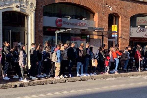 La file d'attente sur le trottoir devant l'arrêt de bus François Verdier.