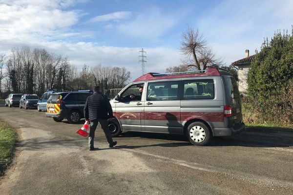 Un véhicule des pompes funèbres franchit le barrage mis en place par les gendarmes autour de la zone de la découverte du cadavre, à Albias (Tarn-et-Garonne).