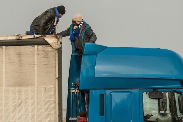 Des migrants tentent de monter dans un camion, à Calais, le 17 décembre 2015.