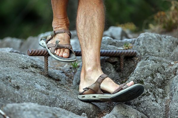 Des pieds en marche sur un sentier de randonnée. 